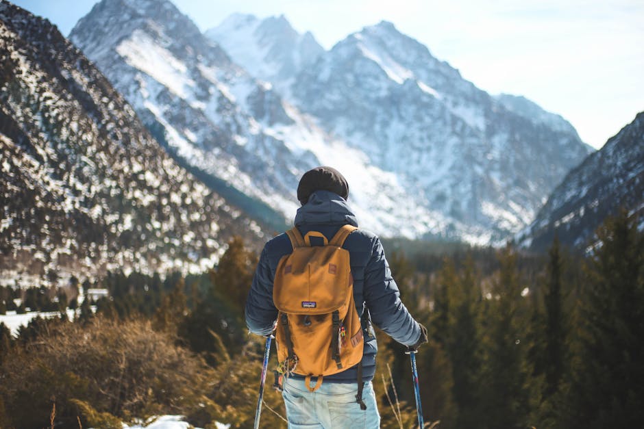 A lone hiker with a backpack explores a scenic winter mountain landscape